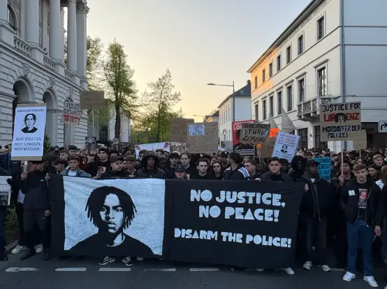 Junge Menschen halten das Frontbanner des Gedenk Spaziergangs mit der Aufschrift "No Justice, no peace! Disarm the police!" Foto: Lasse Deppe