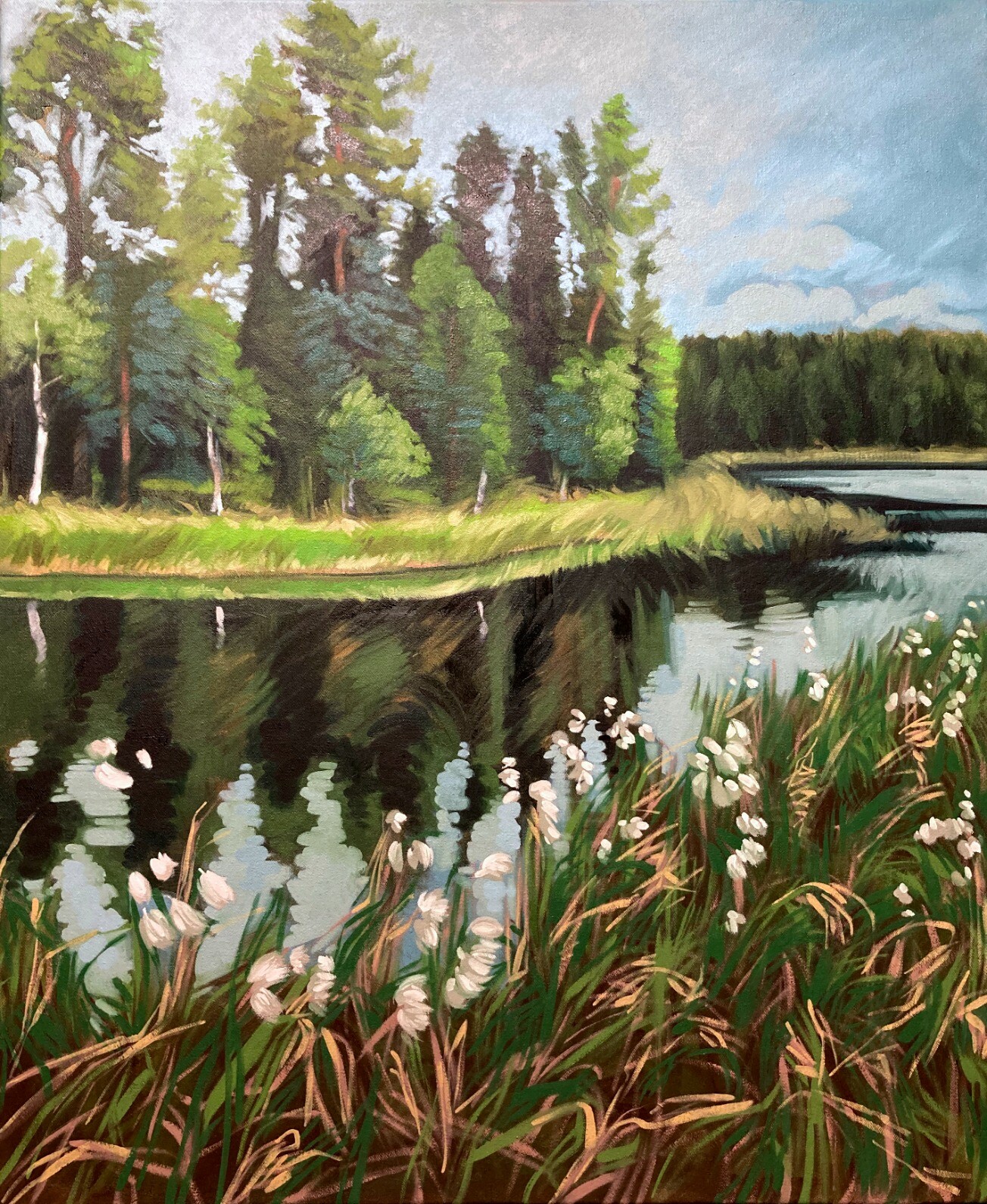 A vertical composition of a lake shore full of blooming cottongrass (tupasvilla) against a lake with relatively calm water reflecting the cloudy sky. The far shore is very close, with birch and pine trees and tall grass along the water.