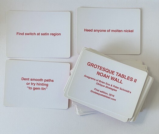 3 cards and a stack of more cards. Each are white with red text. The text on card 1 reads Find switch at satin region, card 2: Heed anyone of molten nickel, card 3: Dent smooth paths or try hinting
"to gem tin". The card on the top of the stack is a title card and reads: GROTESQUE TABLES II
NOAH WALL
Anagrams of Brian Eno & Peter Schmidt's
Oblique Strategies
First edition, 2016
Grotesquetablesii.com