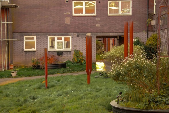 Courtyard inside a modern block of flats with three sculptures in the form of tuning forks.
