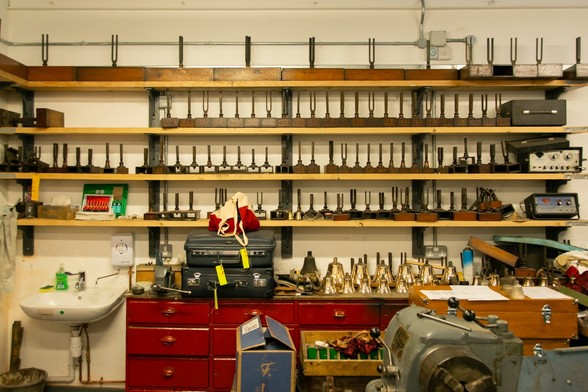Interior if the workshop showing a shelf in the back with a row of tuning forks.