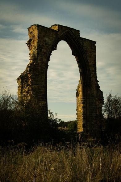 Window arch of the ruin of Dale Abbey in the afternoon sun.