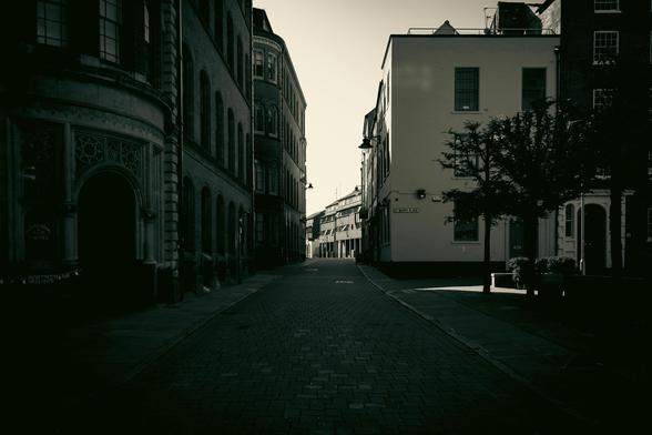 A car-free street in heavy shadows. 