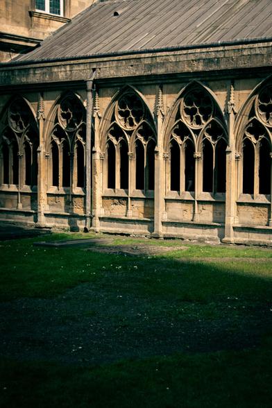 View of the external wall around the garden of the cathedral cloisters with sunlight and shadow.
