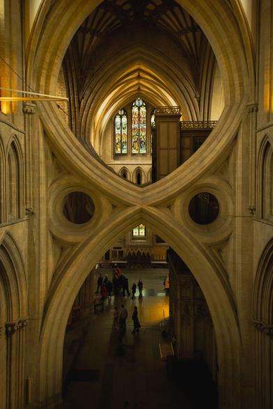 Interior of Wells cathedral looking towards the intricate 'scissor arches' that separate the nave from the transept. In the back is the stained glass of the east window.