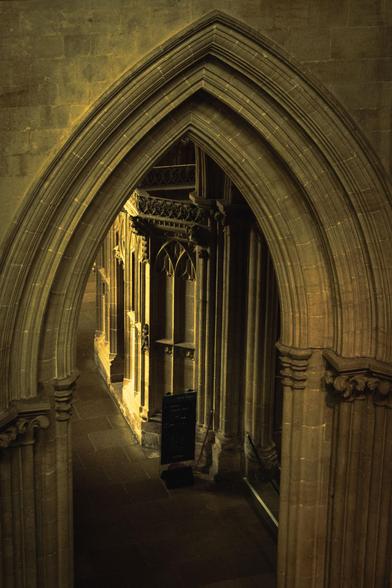 In Well Cathedral, looking down into the nave through an archway towards a side chapel.