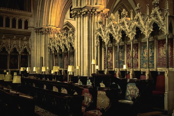 View of the cathedral choir showing the wooden seats with embroidered cushions and ornately carved stalls.
