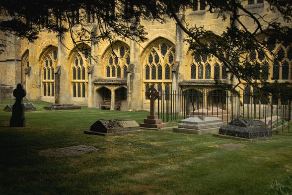 Looking from underneath a tree to some gravestones in the cloisters of Wells Cathedral.