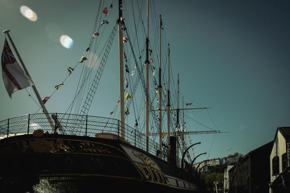 A historic sailing ship against a clear blue sky; bunting on the masts.