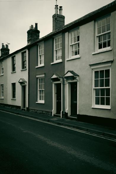 Row of old houses painted in different colours, which are rendered in different tonalities in the black and white image..
