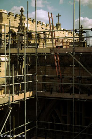 View of the church rooftop with scaffolding in the sunlight.