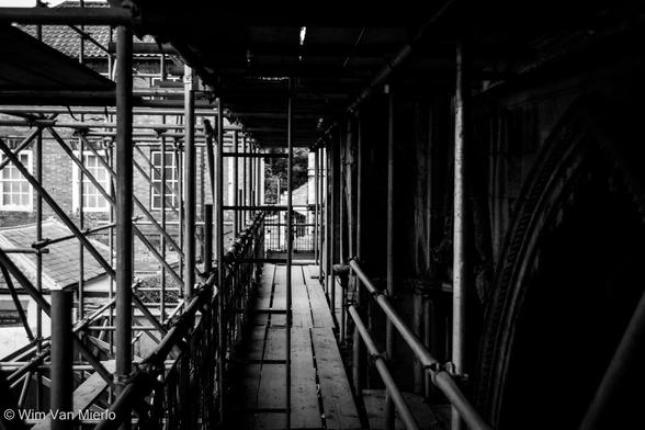 Black and white image with strong shadows. Up on the scaffolding outside the church during restoration work.
