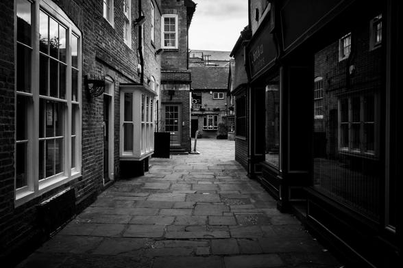 A black and white image of a deserted pedestrianised street.