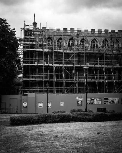 A black and white image of the exterior of the church covered in scaffolding.