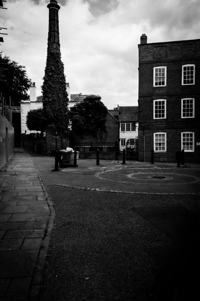 Black and white image of a quiet street withold houses.