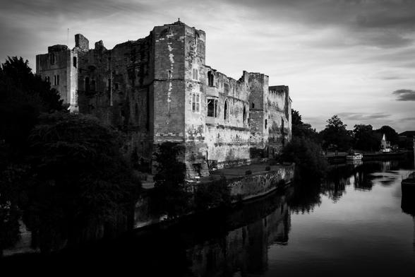  A black and white image of the castle ruins along the river.