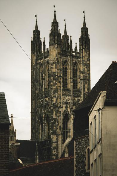 Photograph of the main spire of Canterbury Cathedral rising impressively above the houses.