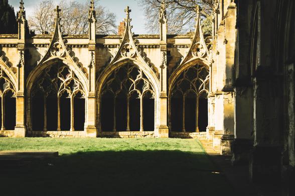 The gothic arches of the cathedral Cloister in bright afternoon sunlight.