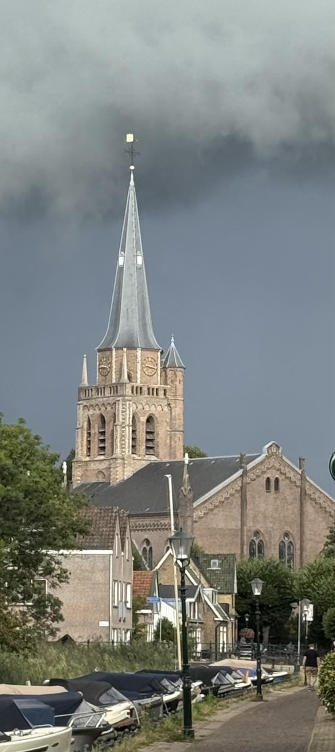 De Dorpskerk in het centrum van Voorschoten, de lucht is donker en dreigend